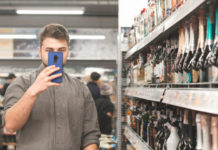 The Top Alcohol Retail Tech Providers for 2020-21 Man in a shirt stands in a supermarket with a shopping cart and holds a smartphone in his hands. Buyer with a smartphone makes a purchase at a supermarket, is in the department of strong drinks